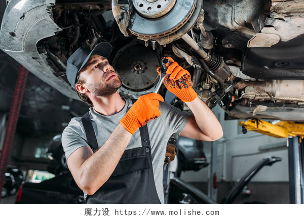 在车底维修的男人车间无车轮机械修理车
